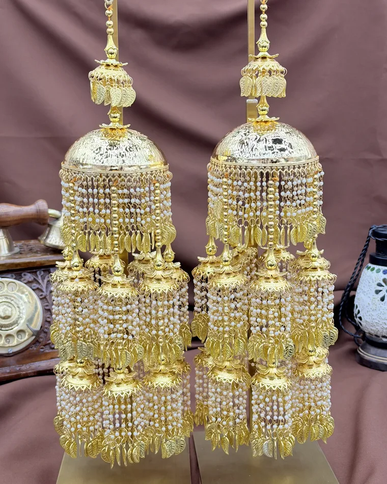Heavy multi-tier gold bridal kaleera with cascading pearl tassels and leaf jhumkis