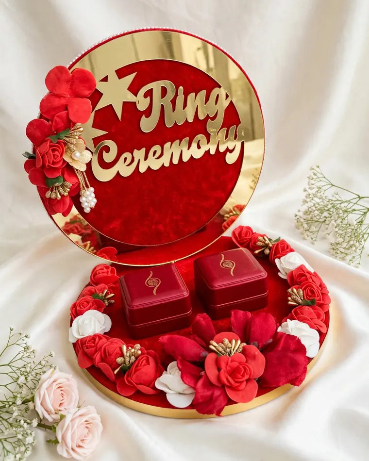 Red and gold velvet ring ceremony platter with ring boxes and floral decor