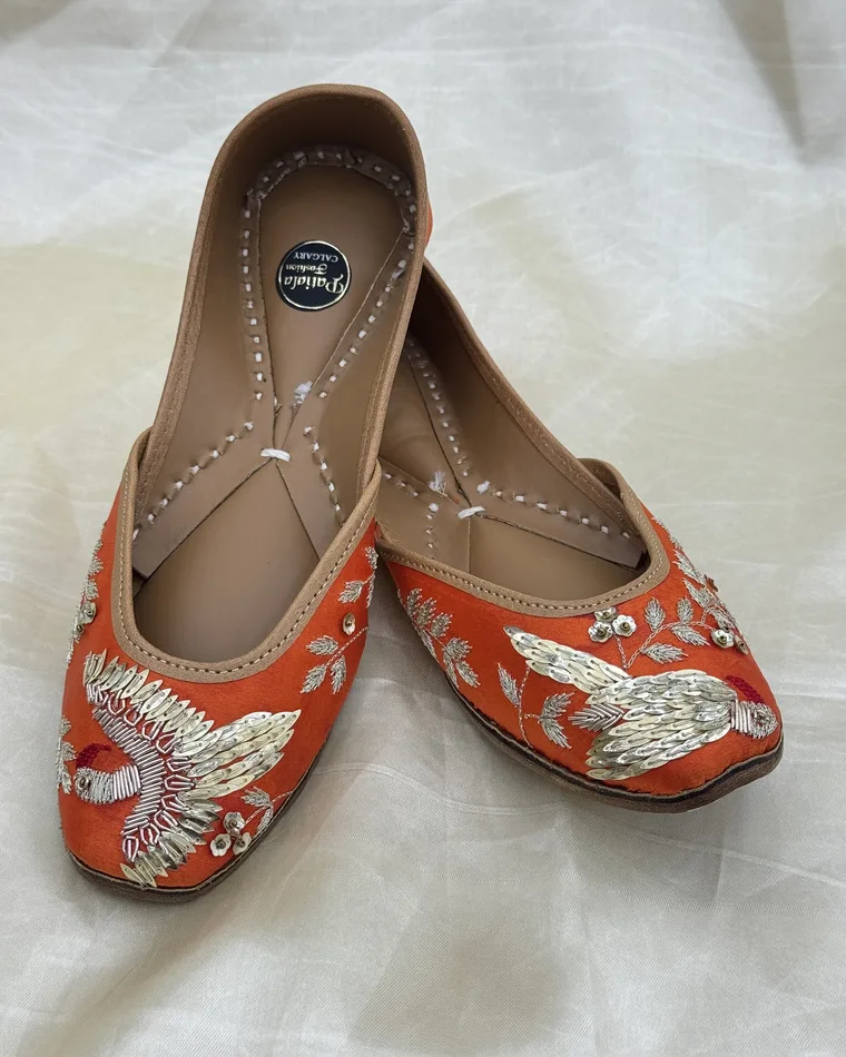 Vibrant orange silk hand-embroidered peacock Punjabi jutti